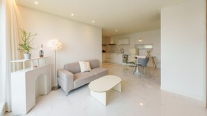 Un salon moderne comprenant un canapé, une table basse et un coin repas avec des chaises et une table.