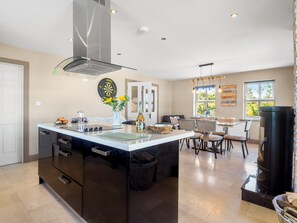 A modern kitchen with a central island, built-in appliances, and a dining area with a view of the outdoors.