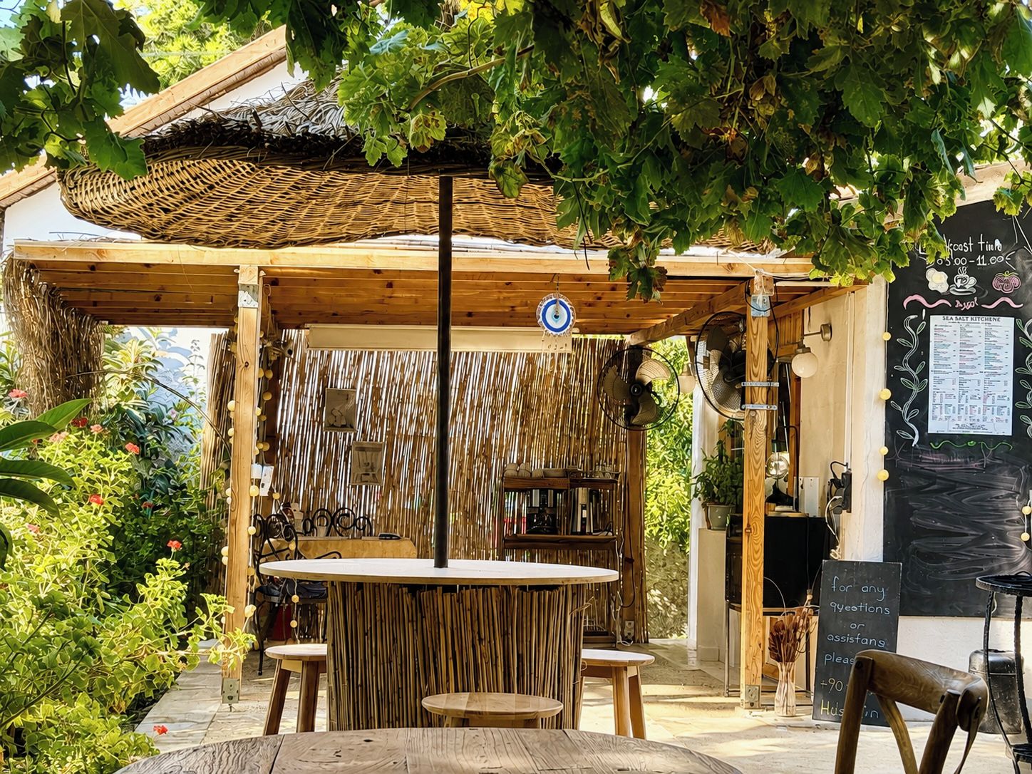 An outdoor seating area with a wooden pergola, a table, and chairs.