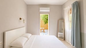 Ein Schlafzimmer mit Bett, Nachttisch, Spiegel und einem Fenster mit Vorhängen.