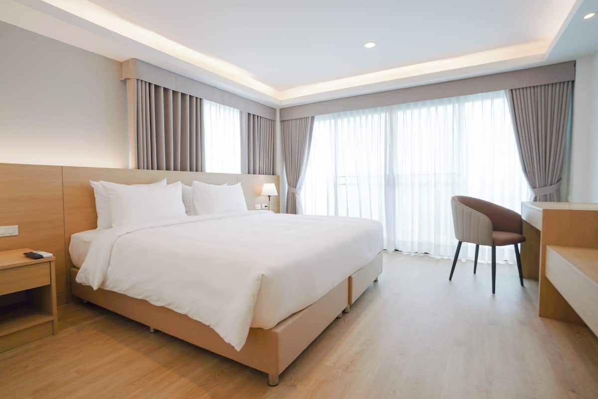 Ein modernes Hotelzimmer mit einem großen Bett, einem Schreibtisch und einem Stuhl.