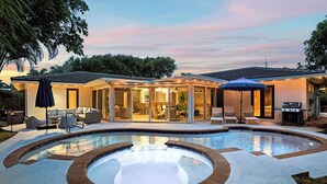 A modern house with a swimming pool, outdoor seating, and a covered patio area. - Pool/Spa & Walk to the Beach Ping Pong Billiards (Palm Beach Shores)