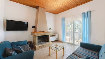 Casa familiare, camere multiple (To Pournari Beachside Garden House) | Area soggiorno | TV a schermo piatto 21 pollici con canali via cavo, caminetto