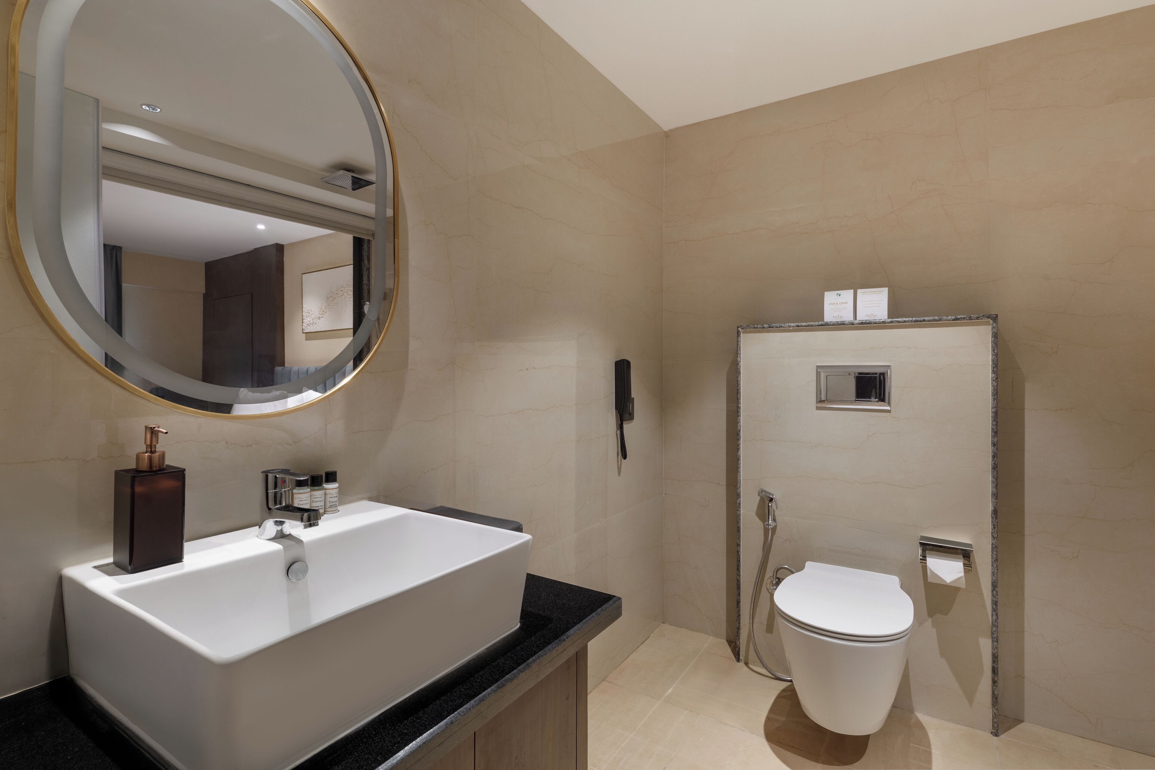 A modern bathroom with a large sink, mirror, and toilet.