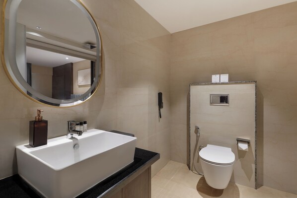 Une salle de bain moderne avec un grand lavabo, un miroir et des toilettes.