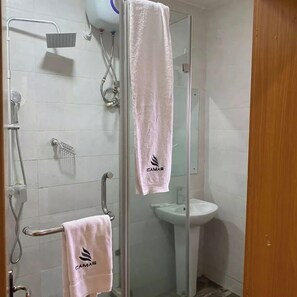 A bathroom with a glass shower enclosure, a white sink, and two towels hanging on towel bars. - Camas Hotels  (Abeokuta)