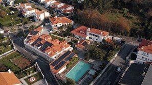 Luchtbeeld van een woongebied met huizen, rode pannendaken en zonnepanelen.