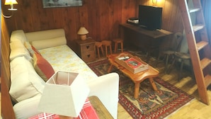 A cozy room with a sofa, a small table, a desk with a computer, and a ladder. - Studio 3 ppl - Ski-in/ski-out - Val d'Isère Center - Wifi (Val-d'Isère)