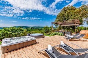 A wooden deck with a hot tub, lounge chairs, and a pergola with outdoor furniture. - Villa Boccaccio (San Gimignano)