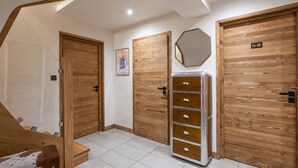 Un couloir avec des portes en bois, un placard à miroir et un escalier.