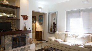 Una sala de estar con chimenea de piedra, un sofá y una mesa de centro.