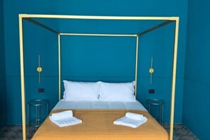 Una habitación con cama con dosel, ropa de cama blanca y dos mesitas de noche.