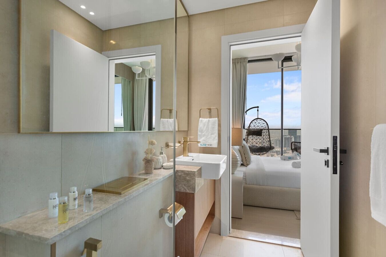 Un baño moderno con un espejo grande, un lavamanos y una ducha.