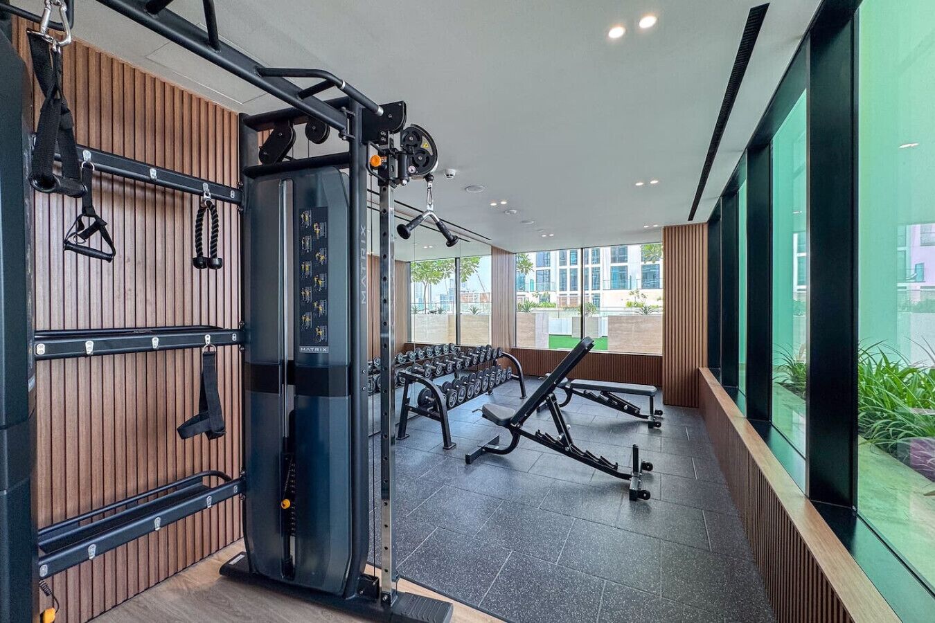 Una palestra moderna con attrezzature per sollevamento pesi, panche e manubri.