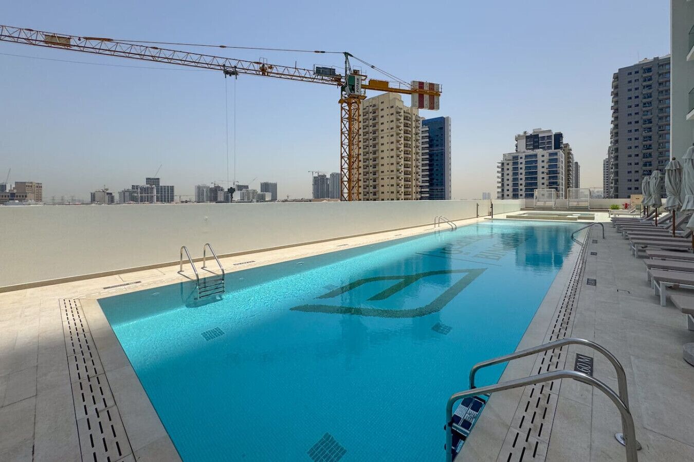 A rooftop pool with a clear view of the city skyline, surrounded by high-rise buildings.