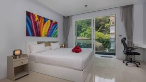 Een moderne hotelkamer met een groot bed, een bureau, een stoel en een schilderij aan de muur.