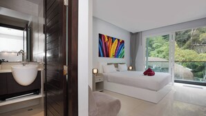 Een moderne slaapkamer met een groot bed, een nachtkastje met lamp, een wit hoofdeinde en een kleurrijk abstract schilderij aan de muur.