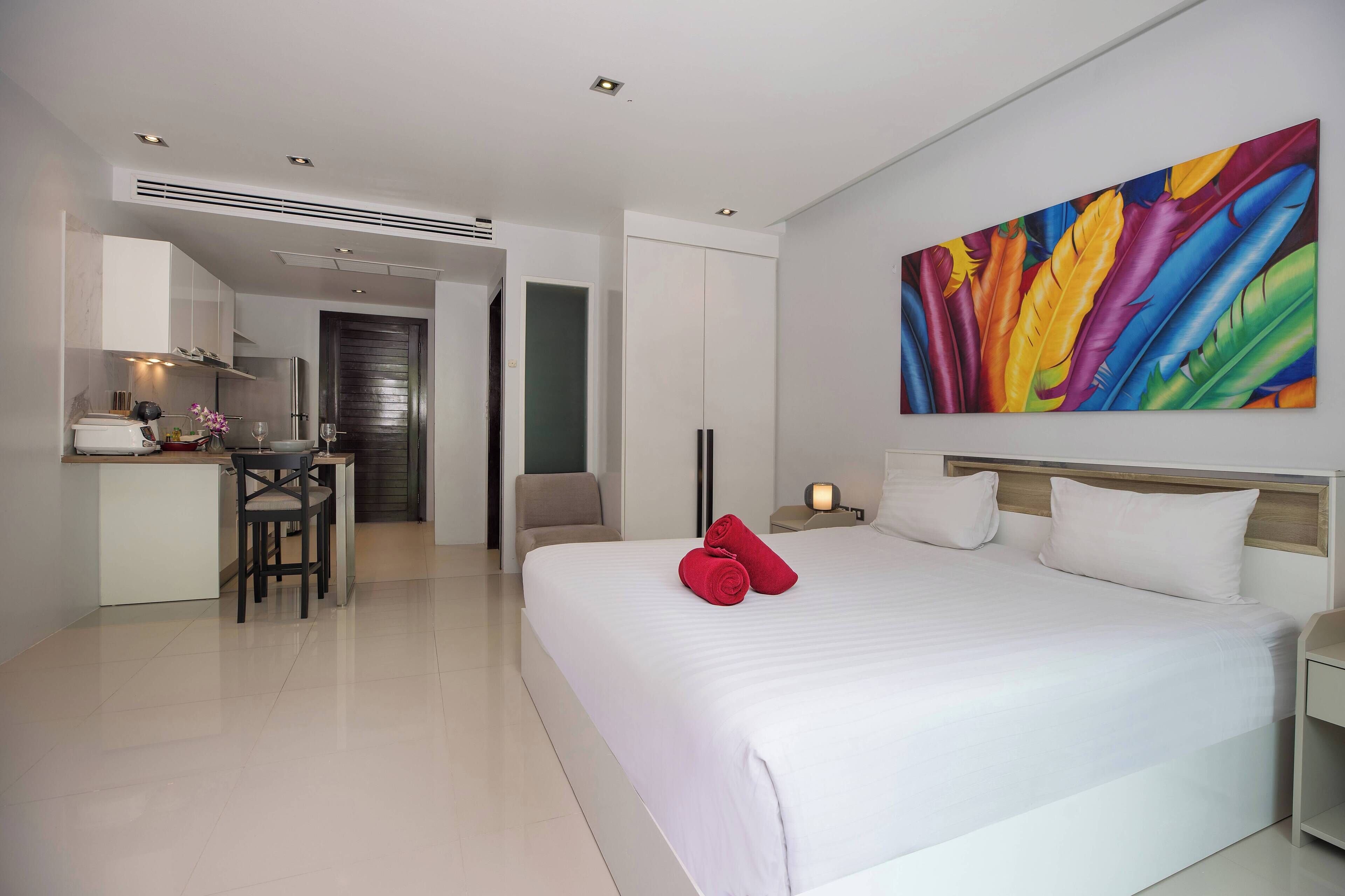 A modern hotel room with a large bed, a desk, and a chair.