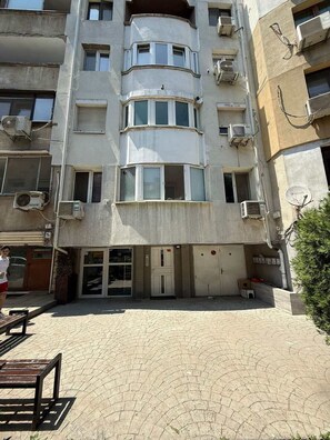 A multi-story building with balconies, air conditioning units, and a gated entrance.