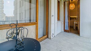 A balcony with a table and chairs, a sliding glass door, and an interior view of a kitchen and dining area. - GuestHost - Cozy apartment of about 80 sqm, able to accommodate up to 5 people, located on the fourth floor of a building with a lift.The property is located in a residential neighborhood of Turin, in an area full of all comforts and well connected to th (Turin)