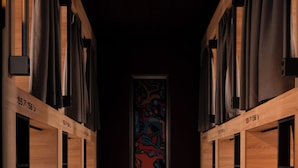 A corridor with wooden lockers and a framed abstract painting on the wall.