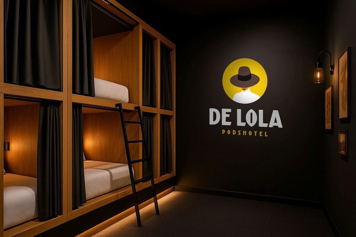 Una habitación acogedora con una cama litera, una escalera y una lámpara fijada a la pared.