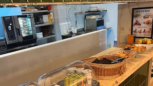A buffet counter with various food items, a microwave, and a sink.