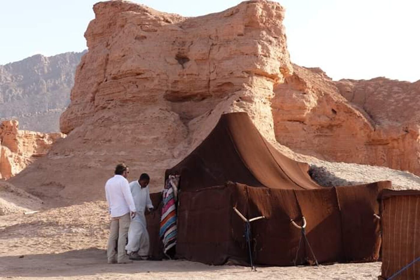 Una tienda de campaña en el desierto con un telón de fondo rocoso.