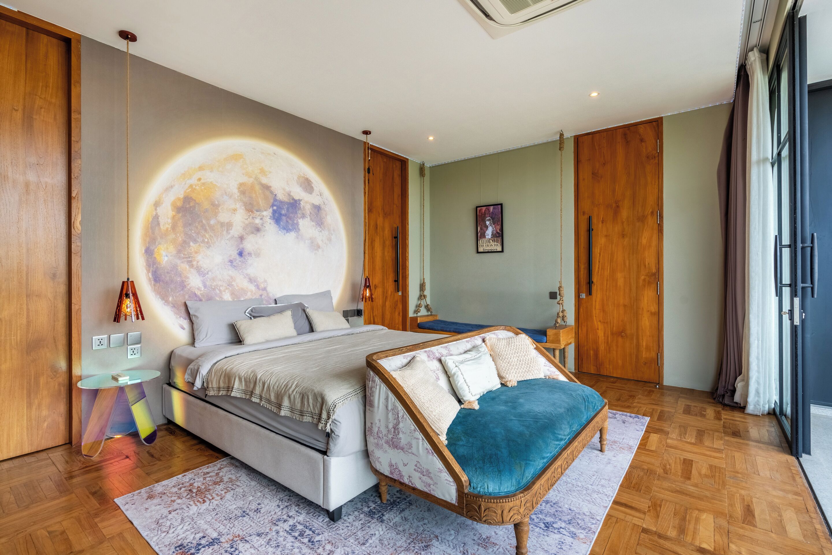 A modern bedroom with a large bed, a chair, a wall mural, and a wooden floor.