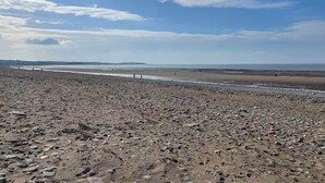 A rocky beach with a clear sky. - Sun House (Maryport)
