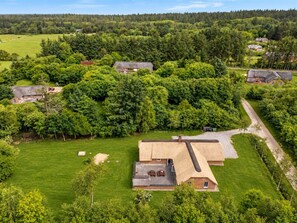 An aerial view of a rural property with a large house surrounded by dense forest, a well-maintained lawn, and a gravel driveway. - "Ulf" - 2km from the sea by Interhome (Ulfborg)