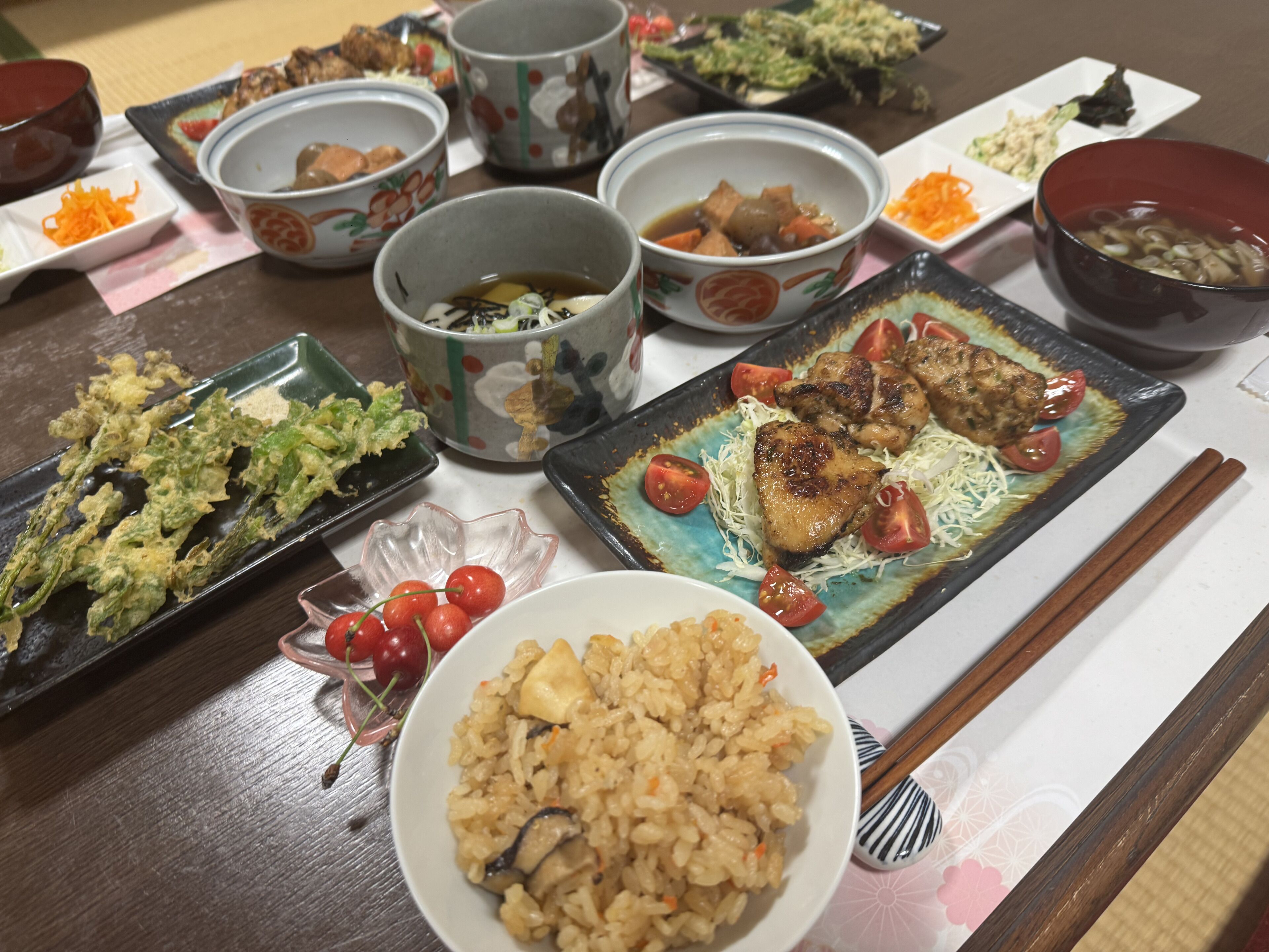 A table with various dishes, including rice, vegetables, and meat, suggesting a meal setting.