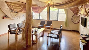 A room with a wooden floor, a large window, and a table with chairs. - Sasanoyu (Katashina)