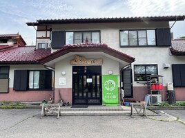 Un edificio de estilo arquitectónico tradicional, con tejado de tejas y puerta de madera.