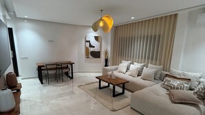 Ein modernes Wohnzimmer mit Sofa, Couchtisch und Esstisch.