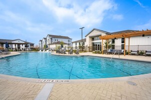 Una piscina al aire libre, sillones reclinables de piscina