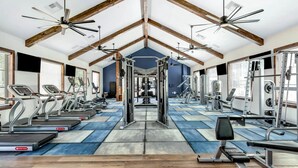 A gym with treadmills, weight machines, and a blue and gray floor. - Balch Road Apartments by Landing (Madison)