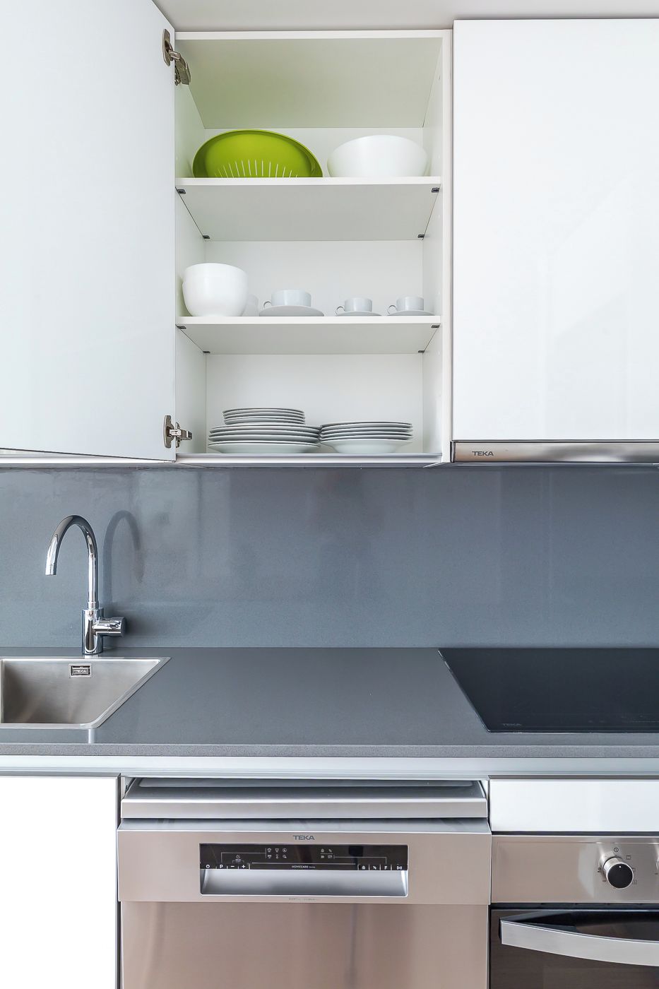 A kitchen with white cabinets, a stainless steel sink, and a dishwasher.