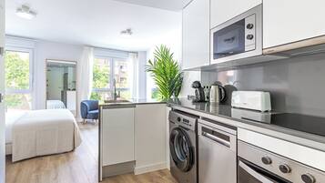 A modern kitchen with a washing machine, microwave, and toaster.