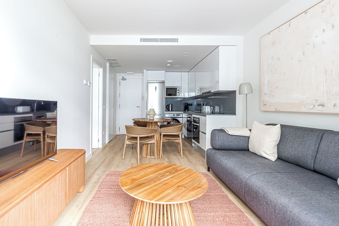 A modern apartment with a kitchen, dining area, and living room.