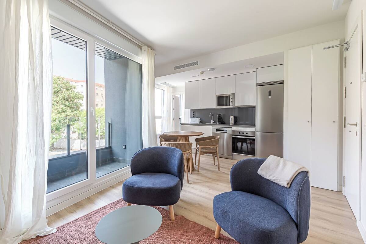 A modern apartment with a kitchen, dining area, and two seating areas.