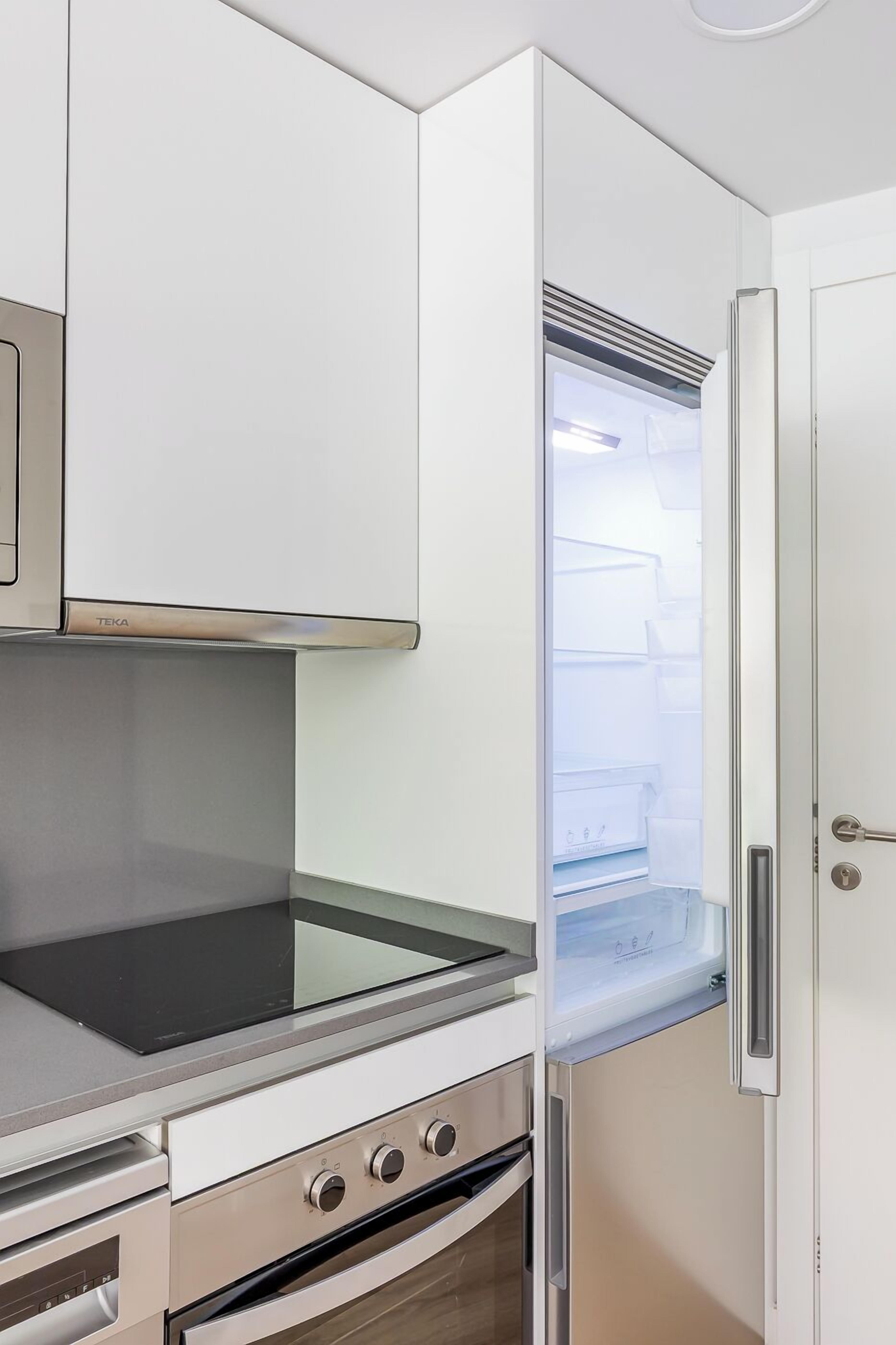 Una cocina compacta con estufa, horno y refrigerador integrados.