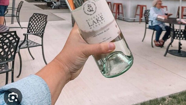 Una persona sostiene una botella de Sauvignon Blanc de Buckeye Lake Winery.