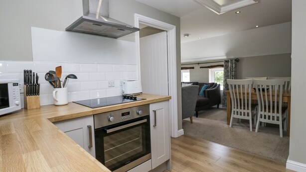 A modern kitchen with a built-in oven, a microwave, and a stainless steel range hood.
