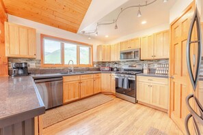 A modern kitchen with wooden cabinets, a stainless steel dishwasher, a microwave, and an oven. - Slate View Dreams,  Close to CB, hot tub, deck, patio, firepit, views! (Crested Butte)