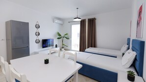 A compact living space with a kitchenette, a dining area, and a sofa bed. - Captain's Residence (Ksamil)