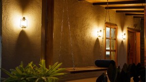 A porch with a swing, a wooden bench, and a potted plant. - Lavender Villa by Ebony Stays – Peaceful 3 BHK Getaway in Nashik (Gangavhare)