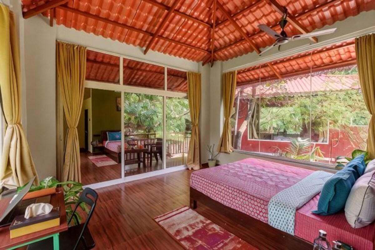 Une chambre à coucher comprenant un lit, un bureau, une chaise, une fenêtre et une porte coulissante.