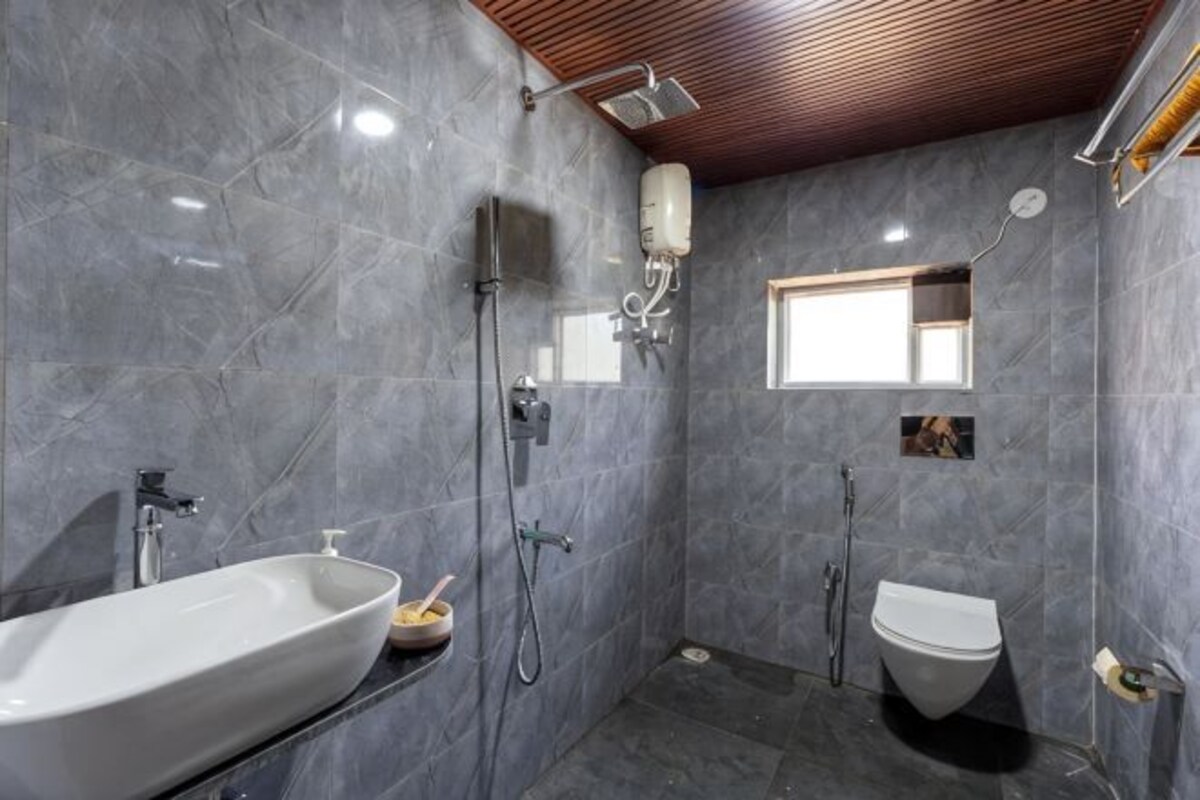 Un baño moderno con una bañera independiente, ducha e inodoro.