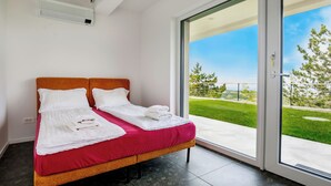 A double bed with white linens, a red bedspread, and a view of a green landscape through a glass door. - La Lita. Panoramic Sea View- Fast Wi-Fi -Free Parking (Šmarje pri Kopru)